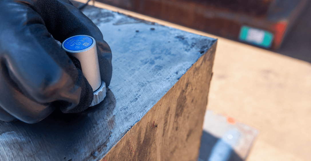 Fotografia de um ensaio por ultra-som a ser realizado num bloco de aço