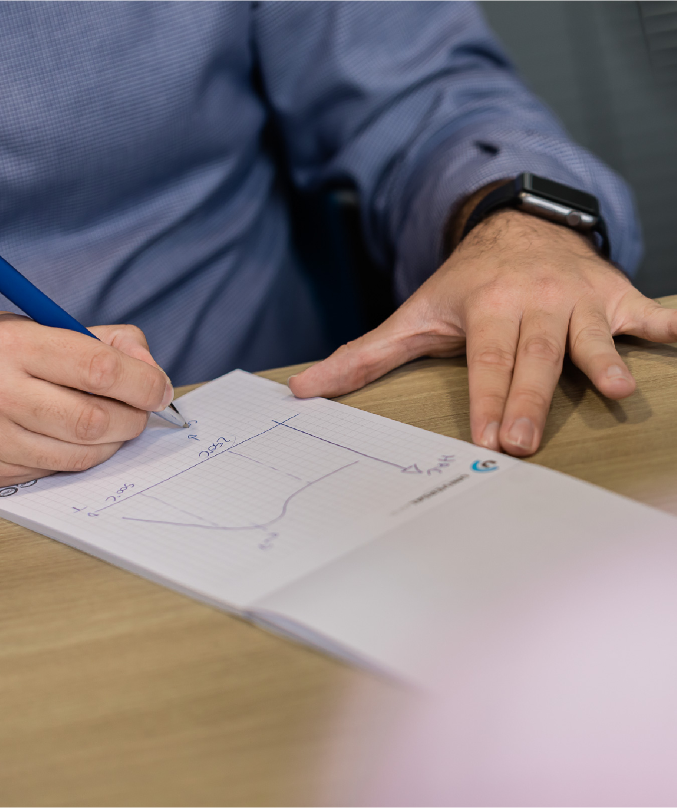 Um homem desenha um gráfico num bloco de notas